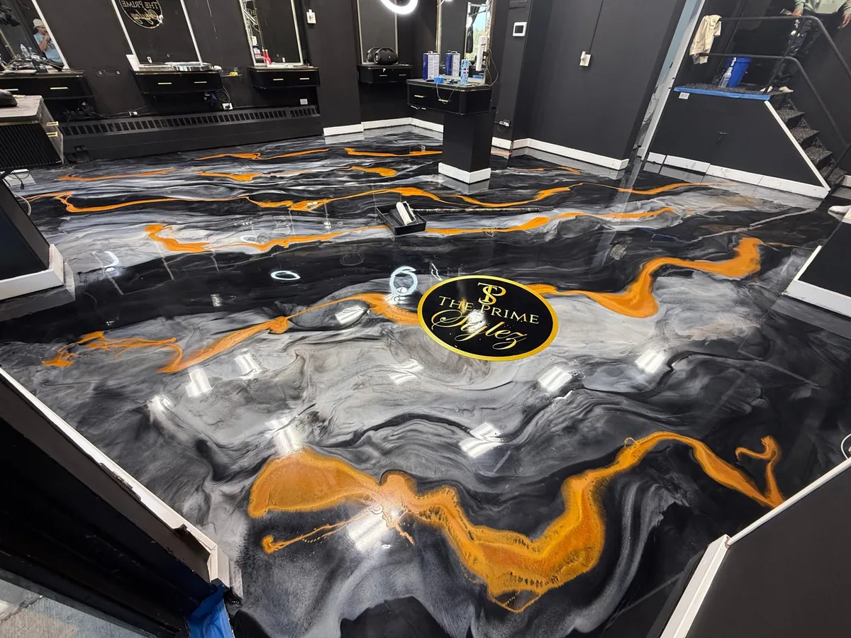 A grey metallic floor with orange veins and a logo set into it, in a salon