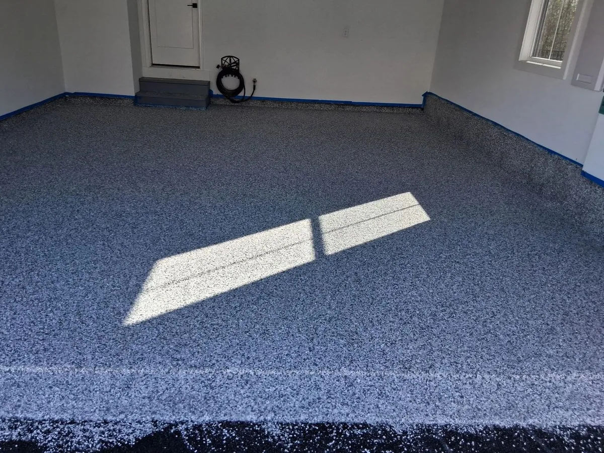 A blue-grey flake garage floor with the coating carried up the wall edge